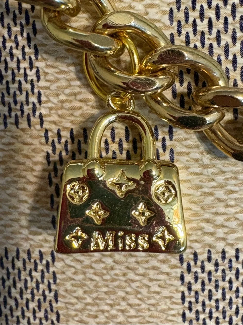 Authentic Louis Vuitton Lock Charm and other unbranded charms on bag chain
